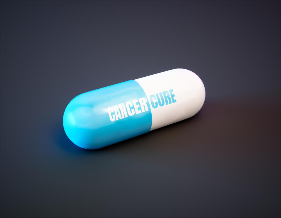 Blue-and-white pill with Cancer Cure printed on it