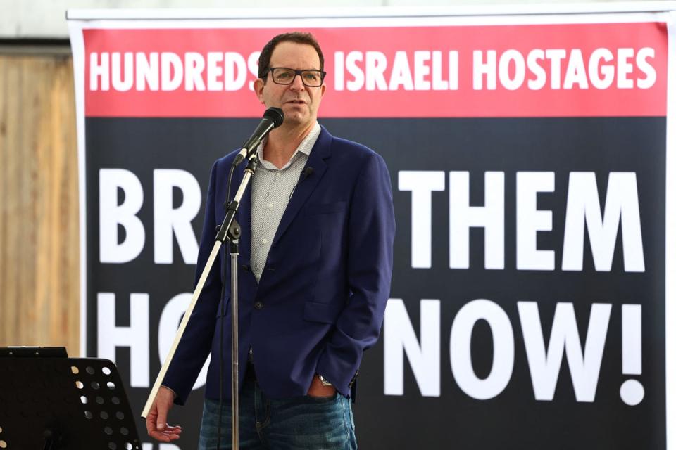 Noam Sagi, son of Ada Sagi, one of the missing Israelis speaks to people viewing the empty places laid out for the 220 hostages on Friday (AFP via Getty Images)