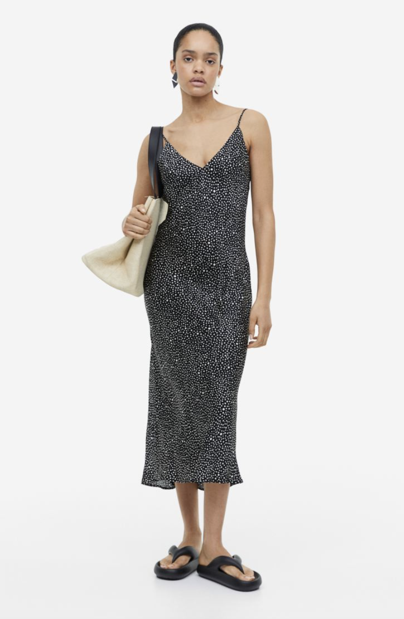 model wearing black sandals and black and white polka dot V-neck Slip Dress (Photo via H&M)