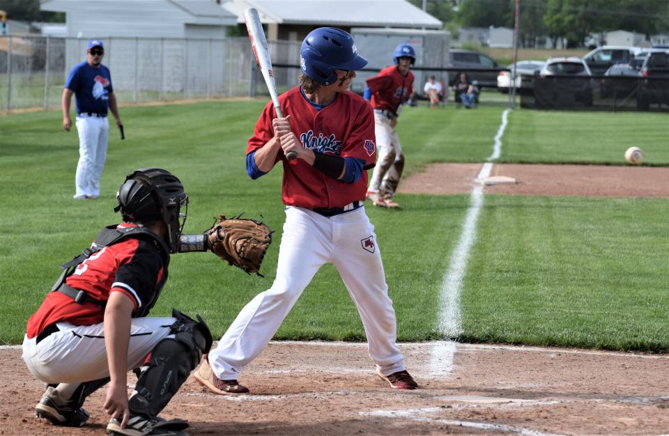 Rudy Hershberger waits on a pitch during the third inning as Dylan Robinson leads off third. The Knights loaded the bases with nobody out in the third inning but came up empty and wound up falling 2-1 to New Philadelphia in the D-II East District championship Wednesday at Sandy Valley High School.