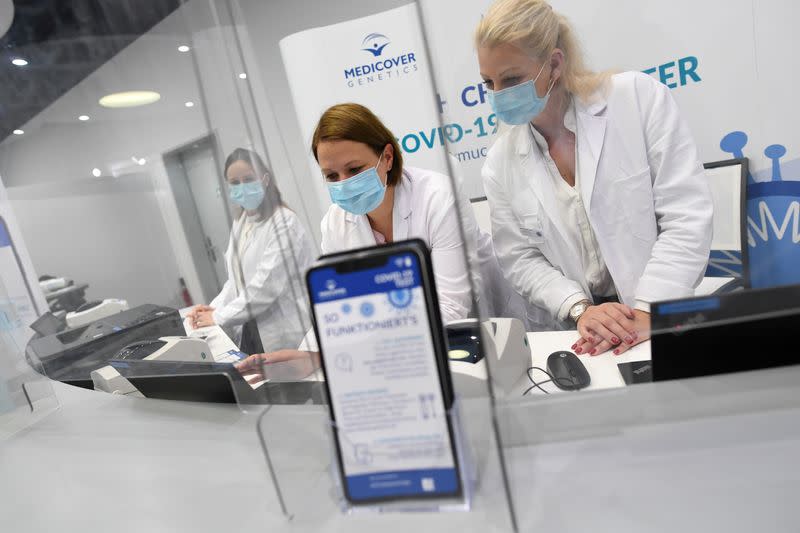 FILE PHOTO: Employees of new COVID-19 quick test center at Franz-Josef-Strauss airport work behind counter in Munich