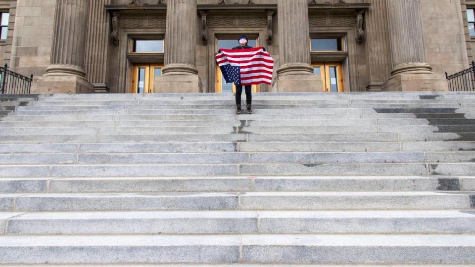 A student holding a U.S. Flag upside down stands atop the steps at the Idaho Capitol Building Monday, April 26, 2021 in Downtown Boise. Cameo W. joined over 100 students gathered at the Statehouse in protest of the Idaho Legislature’s House Bill 337, a bill that includes reference to “critical race theory.”