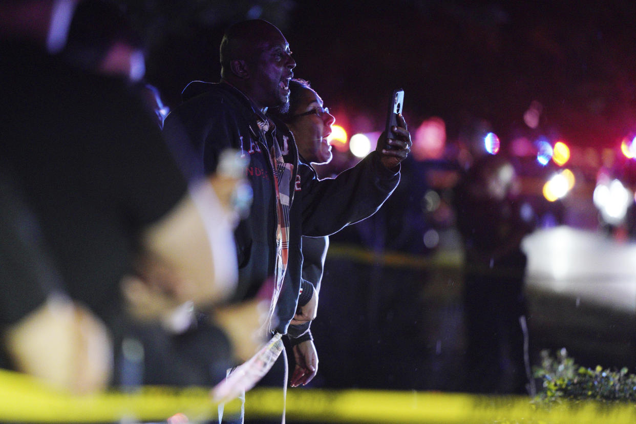 A person take pictures with a cell phone at the scene of an officer involved shooting  on East 77th Street in Richfield, Minn., Saturday night, Sept. 7, 2019. Police near Minneapolis shot and killed a driver following a chase after he apparently emerged from his car holding a knife and refused their commands to drop it. The chase started late Saturday night in Edina and ended in Richfield with officers shooting the man, Brian J. Quinones, who had streamed himself live on Facebook during the chase. (Anthony Souffle/Star Tribune via AP)