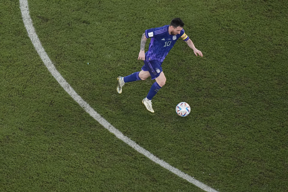 Argentina's Lionel Messi runs with the ball during the World Cup group C soccer match between Poland and Argentina at the Stadium 974 in Doha, Qatar, Wednesday, Nov. 30, 2022. (AP Photo/Pavel Golovkin)