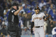 FILE - San Francisco Giants' Donovan Solano disputes a call with home plate umpire Ted Barrett during the eighth inning of Game 3 of a baseball National League Division Series against the Los Angeles Dodgers, Monday, Oct. 11, 2021, in Los Angeles. America is facing a real crisis in prep and youth sports., where fewer and fewer people are willing to take on the thankless job of officiating games. (AP Photo/Ashley Landis, File)