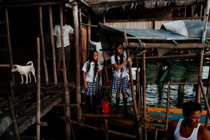 The Wider Image: Rising seas threaten early end for sinking village in Philippines