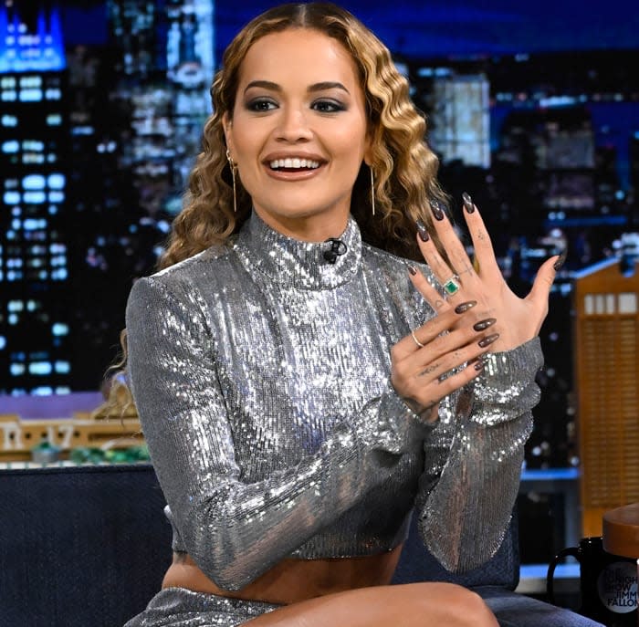 Rita Ora in a sparkly co-ord showing off her emerald engagement ring