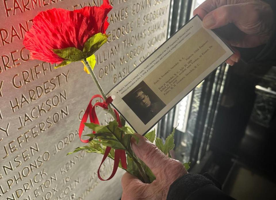 Former vice chancellor for student affairs Thomas Stafford holds a red poppy inside the NC State Belltower