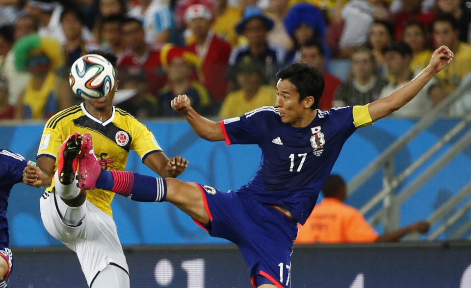 Japan's Makoto Hasebe (R) fights for the ball with Colombia's Carlos Carbonero during their 2014 World Cup Group C soccer match at the Pantanal arena in Cuiaba June 24, 2014. REUTERS/Jorge Silva (BRAZIL - Tags: SOCCER SPORT WORLD CUP)