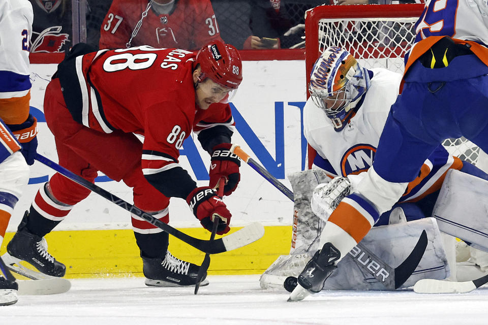 Carolina Hurricanes' Martin Necas (88) tries to slap the puck past New York Islanders' Ilya Sorokin (30) during the first period of an NHL hockey game in Raleigh, N.C., Saturday, Dec. 23, 2023. (AP Photo/Karl B DeBlaker)