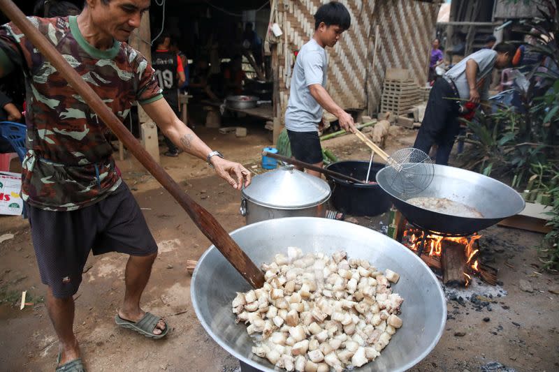 Izzie, 49, former Karenni Army (KNPP) cooks during a death anniversary in the Kayan village where people, who fled from Myanmar during the 1990s war between Myanmar's army and ethnic army groups, live in Mae Hong Son