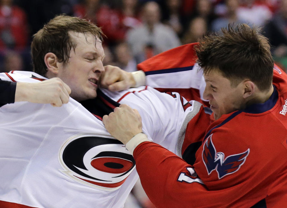 FILE - Washington Capitals defenseman Steve Oleksy, right, lands a punch on Carolina Hurricanes left wing Drayson Bowman during the third period of an NHL hockey game Tuesday, March 12, 2013 in Washington. Oleksy believes fighting will be virtually extinct a decade from now. Oleksy and many others point to junior hockey and even younger levels banning or at least discouraging and not teaching fighting as a bellwether for where it's going. Fewer players coming up through the ranks know how to, or are willing to, fight. (AP Photo/Alex Brandon, File)