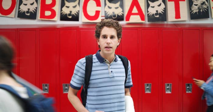 Evan Hansen walking through his high school hallway with a cast on his left arm