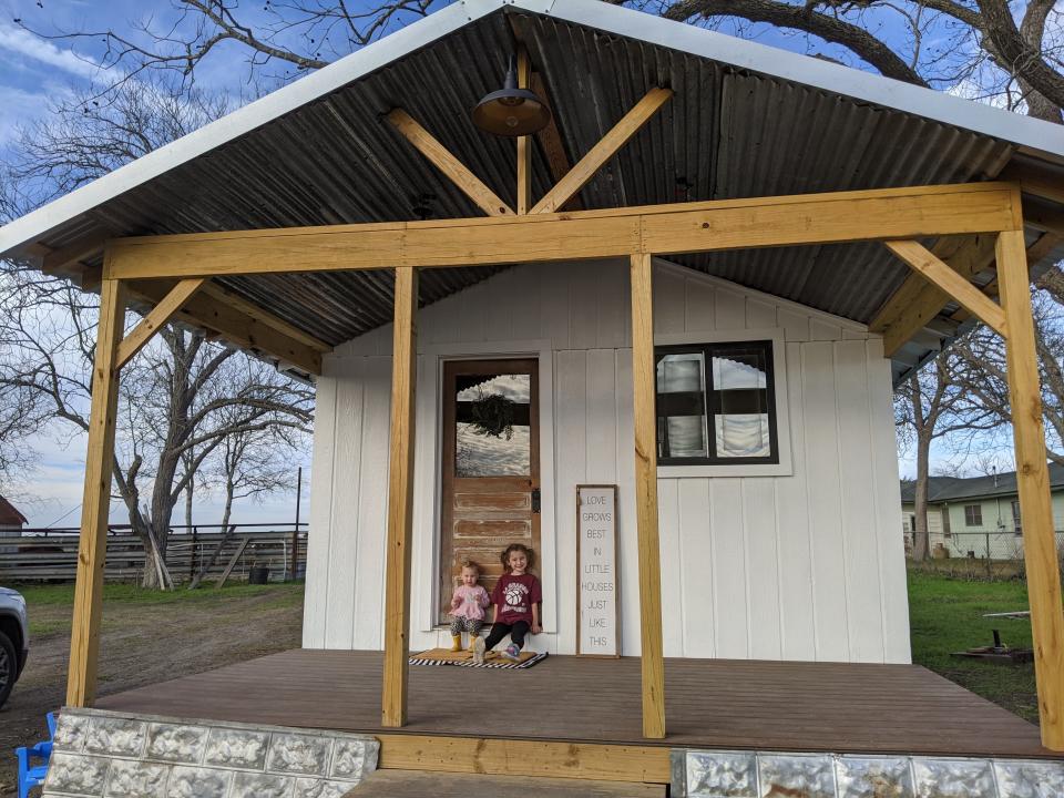 Katy's two daughters sit on their completed porch.