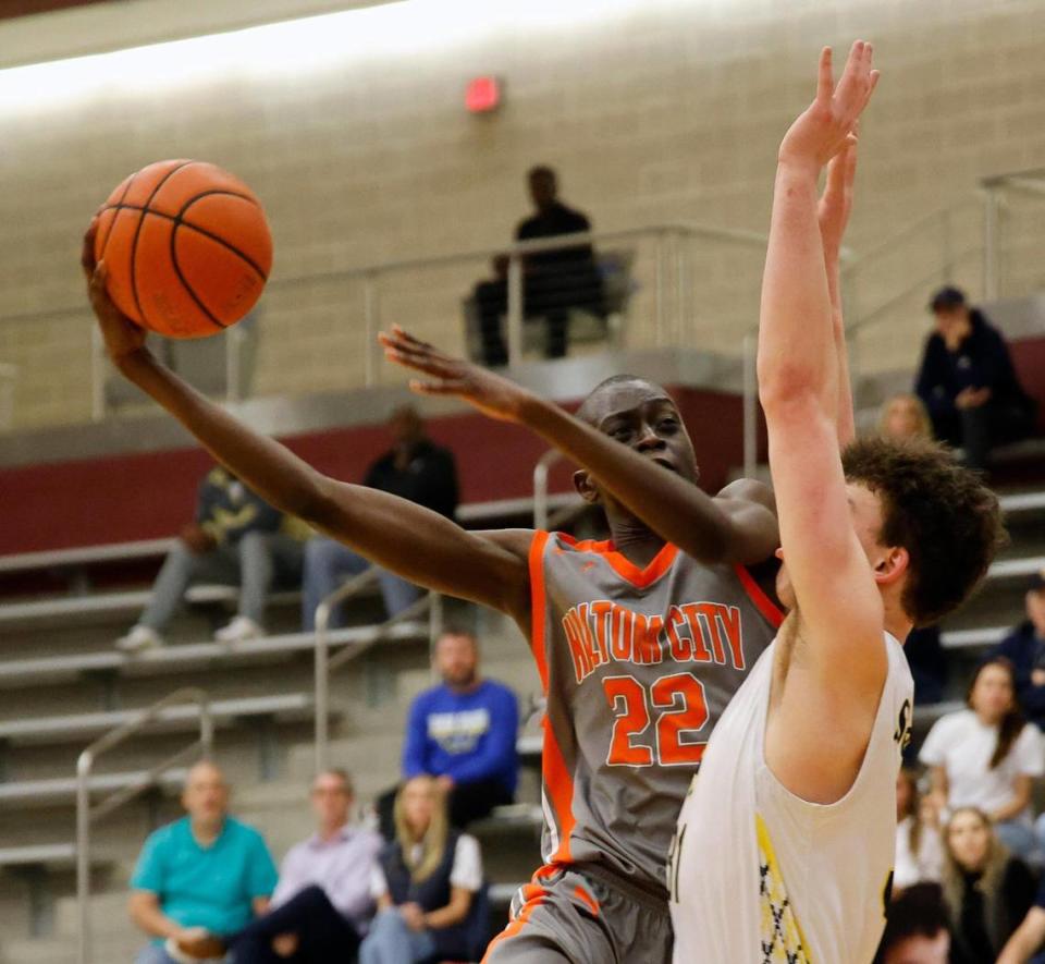 Haltom forward Kuol Atak (22) puts in a right hook defended by Highland Park forward Henry Beckett (31) in the second period of a UIL Conference 6A Division 1 boys bi-district basketball playoff game at Lewisville High School in Lewisville, Texas, Tuesday, Feb. 20, 2024.