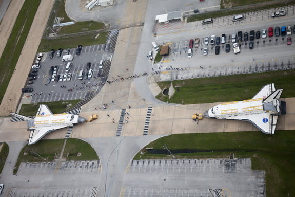 A unique glimpse of operations at NASA's Kennedy Space Center in Florida shows space shuttle Discovery, at right, approaching shuttle Endeavour outside Orbiter Processing Facility-3 (OPF-3). Discovery, which temporarily was being stored in the