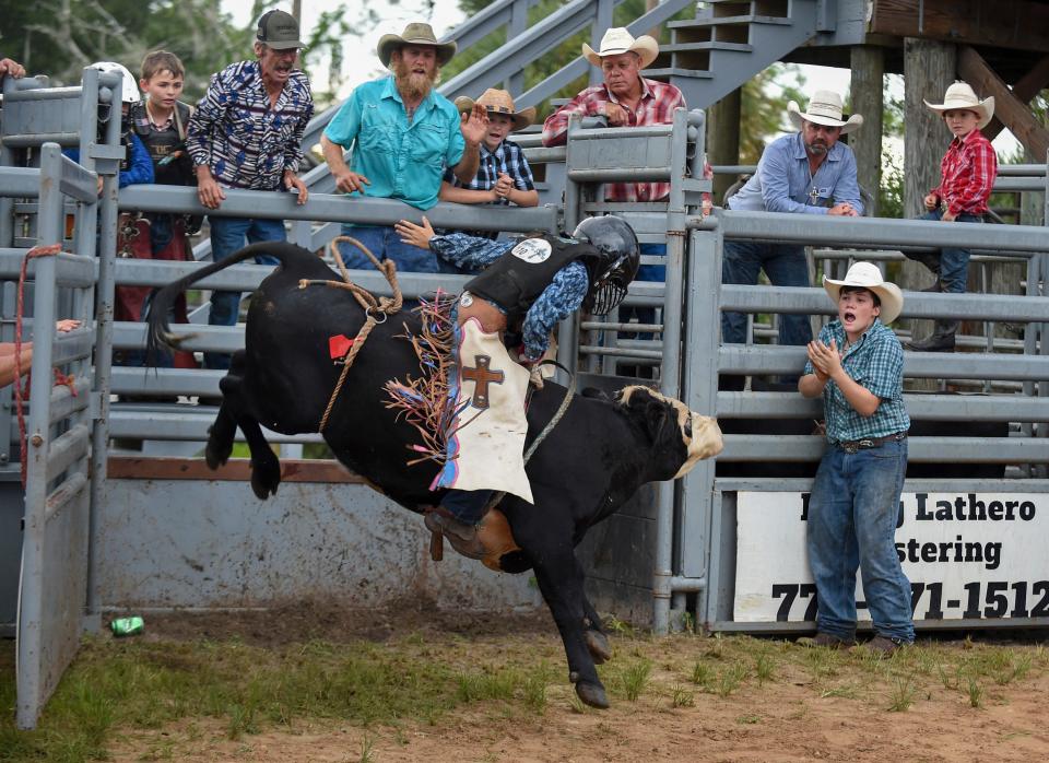 Ten-year-old Trip Burley takes a ride on a bull during the South Florida Mini Bull Tour Season Finals at the Fellsmere Riding Club arena on Saturday, Sept. 10, 2022, in Fellsmere. "My uncle did it and it's just fun. It's like a roller coaster," Trip said.