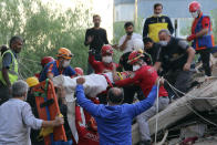 Rescuers carry a man rescued from the debris of his collapsed house, in Izmir, Turkey, Friday Oct. 30, 2020. A strong earthquake struck Friday in the Aegean Sea between the Turkish coast and the Greek island of Samos, killing several people and injuring hundreds amid collapsed buildings and flooding. (Sadik Cangel/IHA via AP)