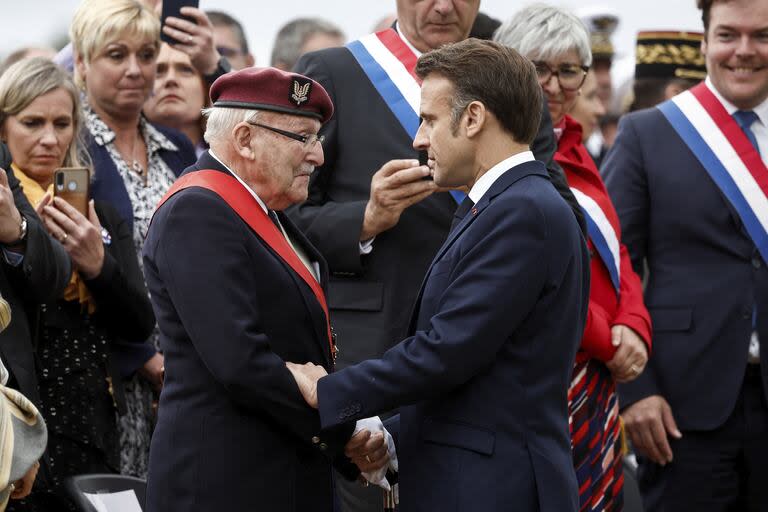 El presidente francés, Emmanuel Macron, le da la mano a Achille Muller, de 98 años, último superviviente de las Fuerzas Francesas Libres, en la ceremonia para rendir homenaje a los maquis de Saint Marcel, una fuerza de combatientes de la Resistencia francesa durante la Segunda Guerra Mundial, el 5 de junio de 2024.