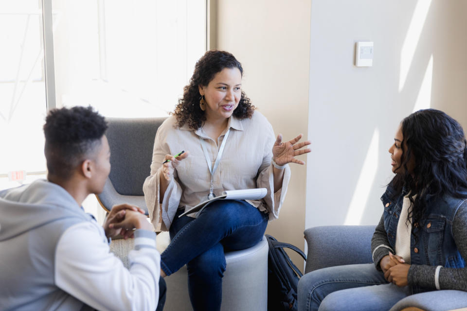 three people sitting and talking