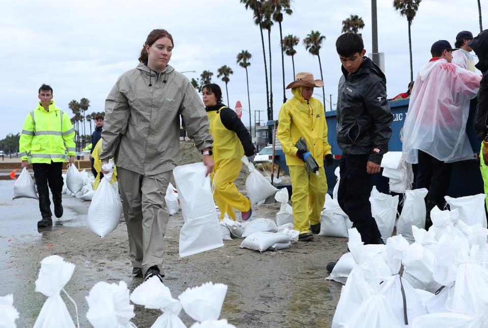 Volunteers and members of the Long Beach Fire Department fill sandbags at Belmont Shore Beach on August 20, 2023 in Long Beach, California.