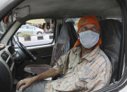 Indian driver Gangaram, 48, who lost his job and business because of the new coronavirus lockdown, sits in his vehicle in New Delhi, India Thursday, June 4, 2020. Gangaram used to pick and drop schoolchildren from a New Delhi neighborhood. The job assured him of slim financial security. to relaunch the economy. That's the harsh truth facing workers laid off around the world, from software companies in Israel to restaurants in Thailand and car factories in France, whose livelihoods fell victim to a virus-driven recession that's accelerating decline in struggling industries and upheaval across the global workforce. (AP Photo/Manish Swarup)