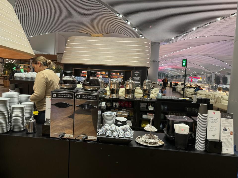 A barista behind a coffee station in an airport.