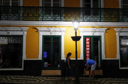 A man installs a board panel for protection before the arrival of Hurricane Lorenzo in Angra do Heroismo in the Azores islands