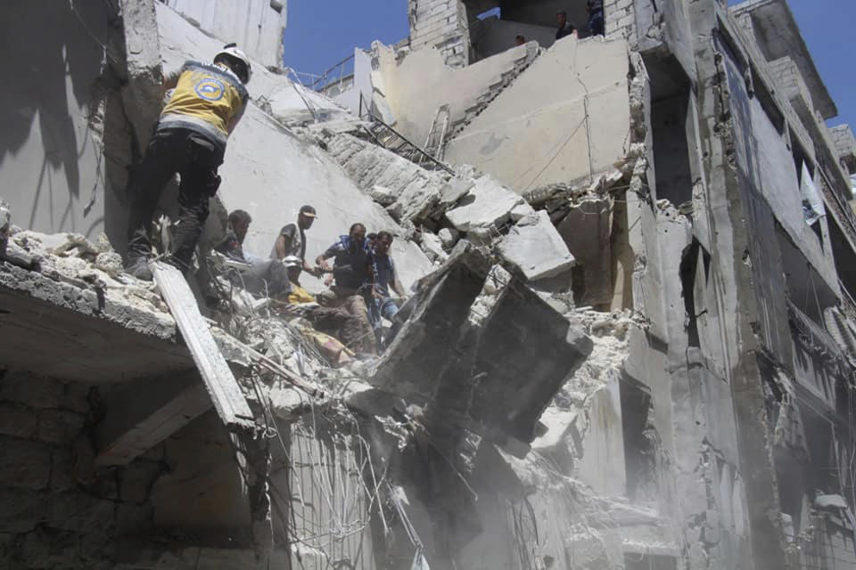 This photo posted on Tuesday, May 28, 2019 and provided by the Syrian Civil Defense White Helmets, which has been authenticated based on its contents and other AP reporting, shows Civil Defense workers inspecting a damaged building after an airstrike by Syrian government forces, in the town of Ariha, in the northwestern province of Idlib, Syria. Syrian activists and rescuers say government warplanes and artillery have pounded the last rebel stronghold in the country, killing over a dozen people. (Syrian Civil Defense White Helmets via AP)