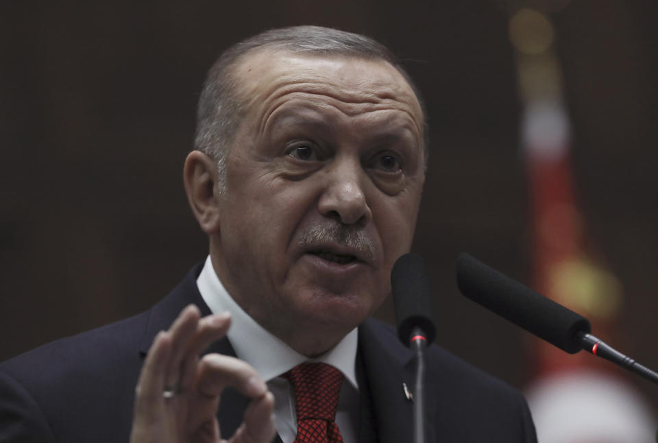 Turkey's President Recep Tayyip Erdogan addresses his ruling party's legislators, in Ankara, Turkey, Tuesday, Jan. 14, 2020. Erdogan said Turkey would closely follow moves by the two sides in Libya and vowed to teach Khalifa Hifter, the head of the self-styled Libyan National Army, "the lesson he deserves" if attacks on the Tripoli government continued.(AP Photo/Burhan Ozbilici)