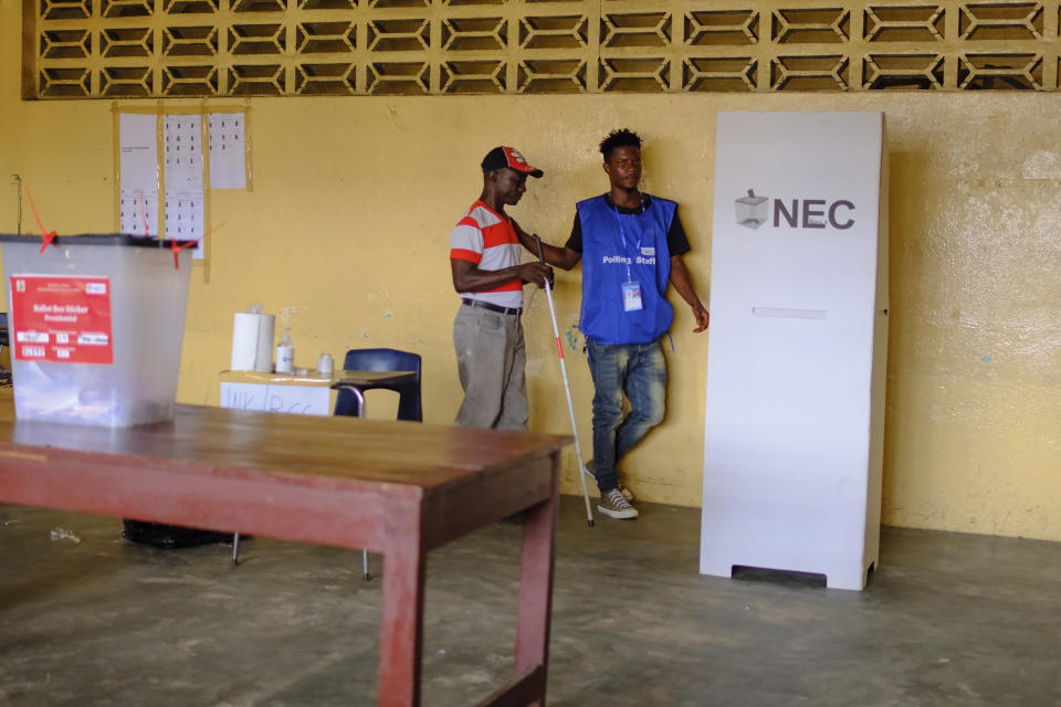 A blind man is assisted to the polling booth in the second round of presidential elections in Monrovia, Liberia, Tuesday, Nov. 14, 2023. Liberian President George Weah, faces a tight runoff election as he seeks to defeat Joseph Boakai, a repeat challenger, and earn a second term in the West African nation. (AP Photo/Rami Malek)