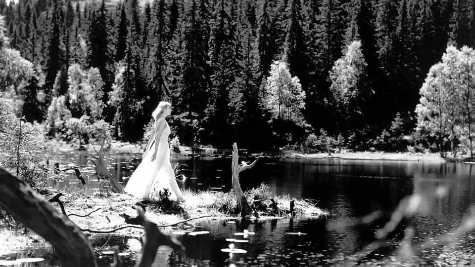 A ghostly woman walks toward a supposedly cursed idyllic lake in the Norwegian folk horror movie Lake of the Dead.