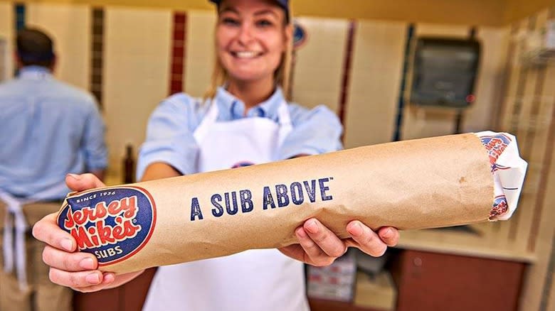 Jersey Mike's worker holding sandwich