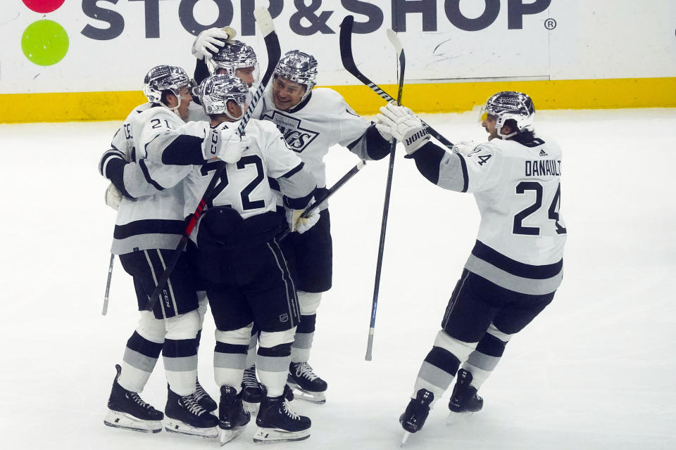 Los Angeles Kings' players celebrate after a goal by teammate Adrian Kempe, second from top left, during the second period of an NHL hockey game against the New York Islanders, Saturday, Dec. 9, 2023, in Elmont, N.Y. (AP Photo/Bebeto Matthews)