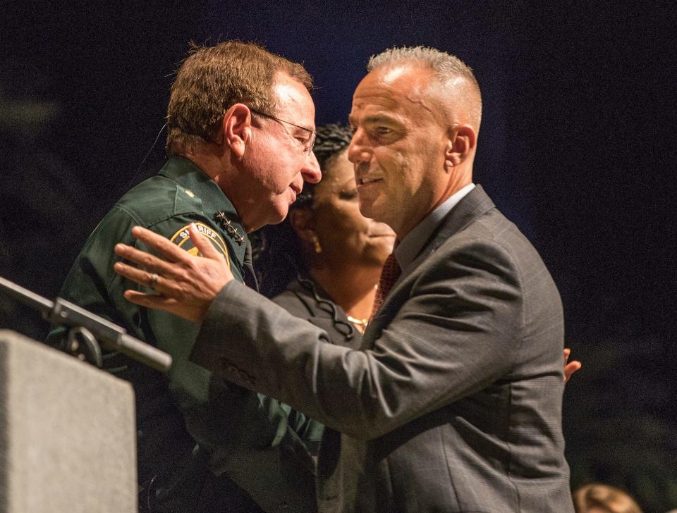 Andrew Pollack ,right ,whose daughter Meadow was killed in the Parkland shooting , hugs Polk County Sheriff Grady Judd during the School Safety Guardian program graduation ceremony at the RP Funding Center in Lakeland Fl . Monday  July 30 2018. ERNST PETERS/THE LEDGER