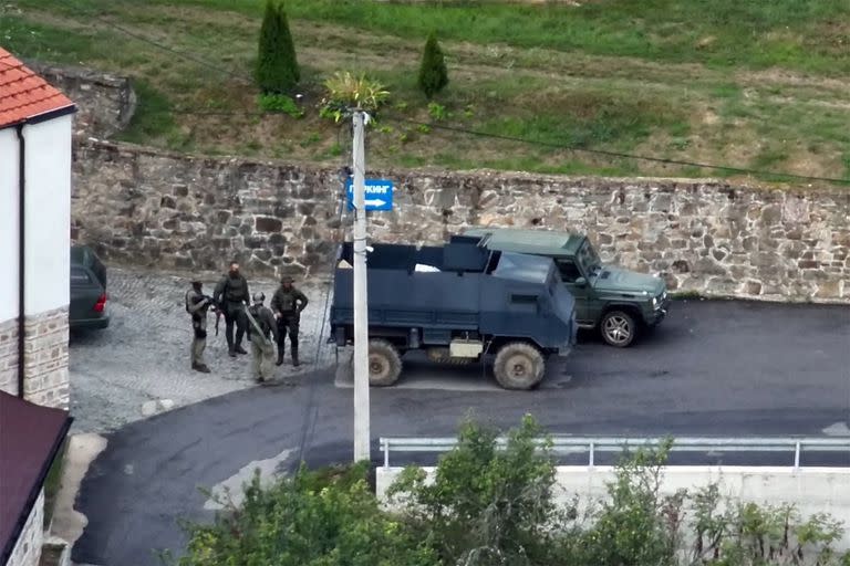 Esta imagen tomada y publicada por el gobierno de Kosovo el 24 de septiembre de 2023 muestra a individuos armados parados junto a un vehículo blindado cerca de la entrada al monasterio de Banjska ocupado por hombres armados, en la aldea de Banjska en el norte de Kosovo.