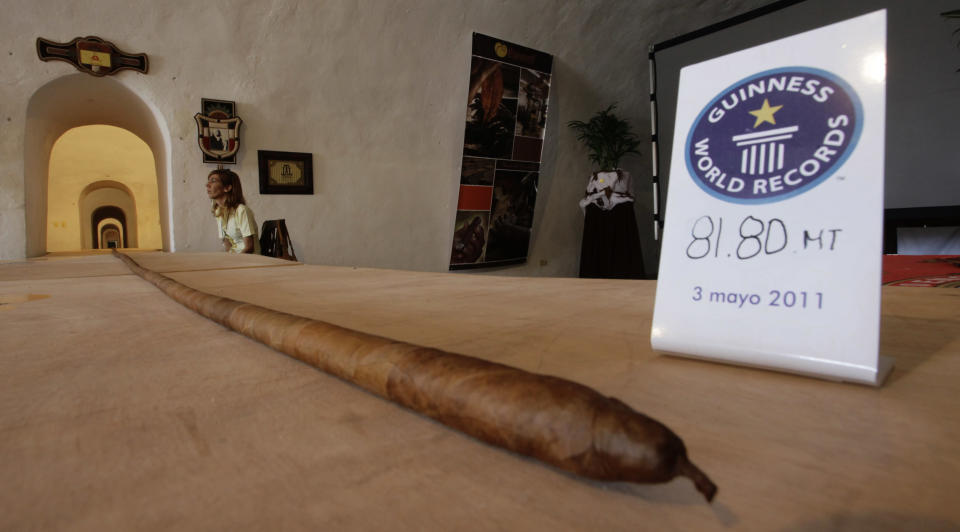 The world's longest cigar that stretched 268 feet 4 inches (81.8 metres), or most of the length of a football field, is seen in Havana May 3, 2011. Resting on tables, it sprawled through El Morro, an old Spanish fort overlooking Havana Bay, where Cuba is holding its annual International Tourism Fair. The cigar, once it is officially accepted by Guinness World Records in London, will eclipse the previous record cigar of 148 feet 9 inches (45.38 metres), both rolled by Jose Castelar Cairo, better known as "Cueto". REUTERS/Desmond Boylan