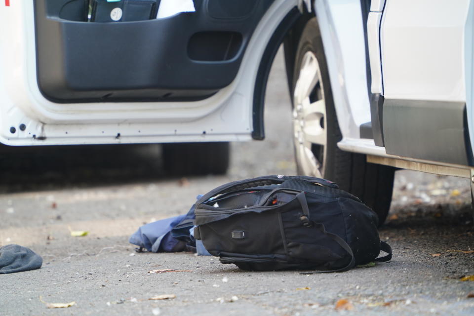 A bag lies beside a white van behind a police cordon on the corner of Maples Street and Bentinck Road in Nottingham. (PA)