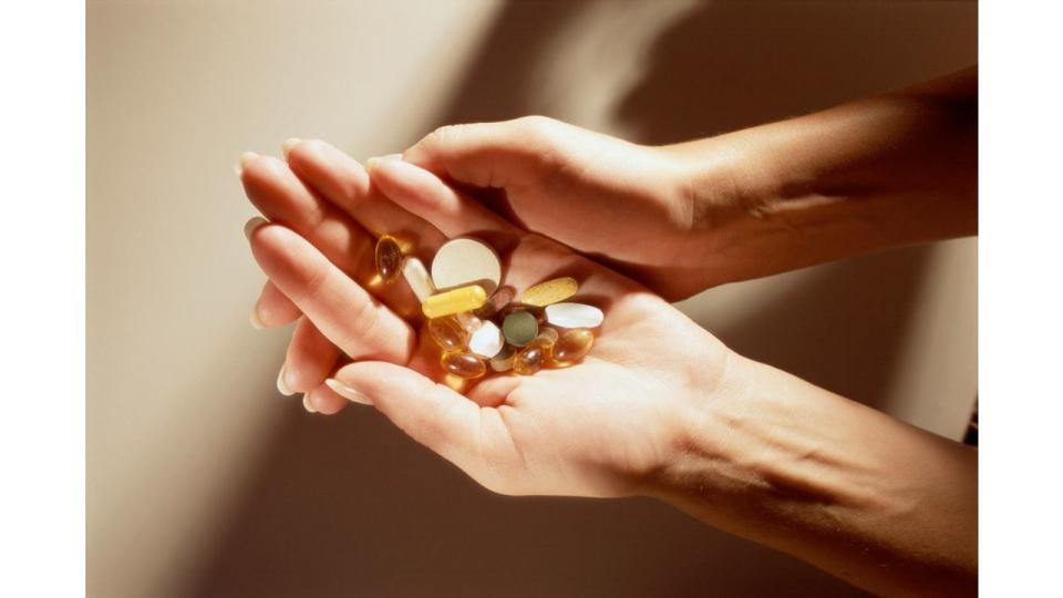 women holding a handful of supplements