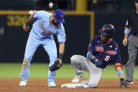 Texas Rangers shortstop Isiah Kiner-Falefa, left, tries to tag Minnesota Twins Andrelton Simmons, right, who reached second on a double in the sixth inning at a baseball game Sunday, June 20, 2021, in Arlington, Texas. (AP Photo/Richard W. Rodriguez)