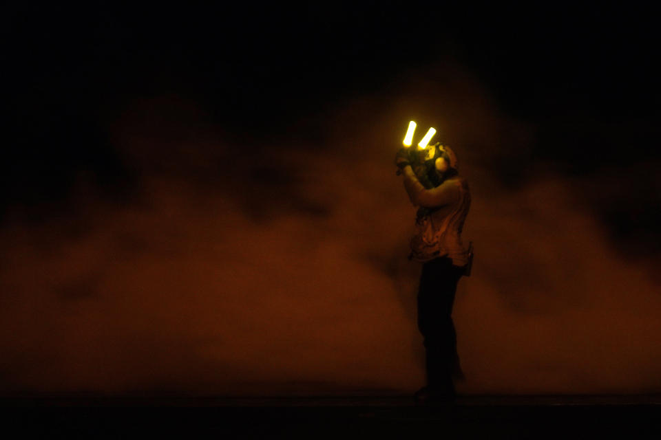 A sailor signals a fighter jet preparing to launch off the USS Dwight D. Eisenhower aircraft carrier in the Red Sea on Tuesday, June 11, 2024. (AP Photo/Jon Gambrell)