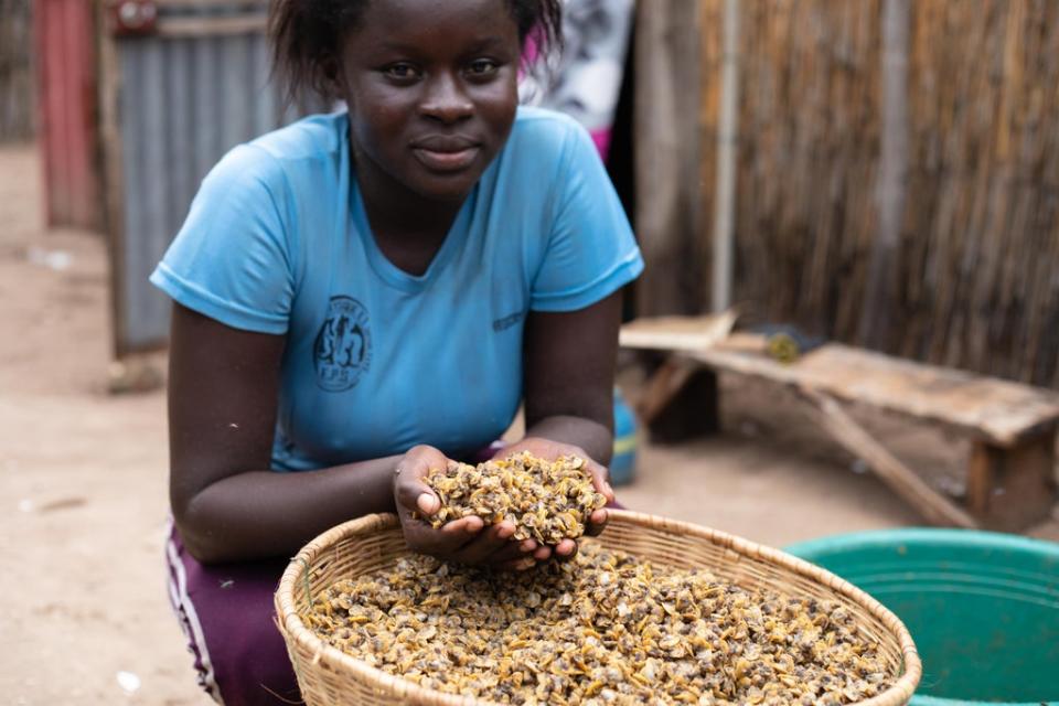 Coumba Manka, 19, a fish processor, holds cockles that have been removed from their shell at a community in Joal-Fadiouth (Randa Osman/MSI Reproductive Choices)