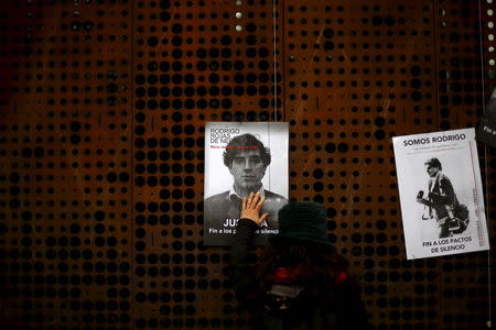 A woman touches a poster of U.S. citizen Rodrigo Rojas, a 19-year-old U.S. student who was killed during a Santiago labor strike in 1986, during a rally to claim justice at Santiago, Chile, July 28, 2015. REUTERS/Ivan Alvarado