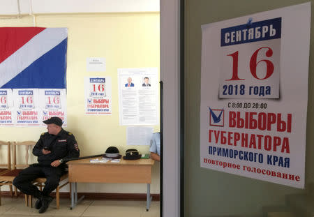 FILE PHOTO: A policeman guards a polling station during the gubernatorial election in the far eastern city of Vladivostok, Russia September 16, 2018. Picture taken September 16, 2018. REUTERS/Yuri Maltsev/File Photo