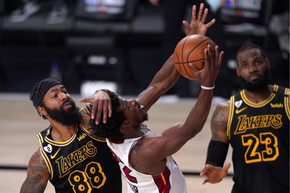 Los Angeles Lakers' Markieff Morris (88) delivers a hand to the head of Miami Heat's Jimmy Butler on a shot attempt as LeBron James (23) looks on during the first half of Game 2 of basketball's NBA Finals, Friday, Oct. 2, 2020, in Lake Buena Vista, Fla. (AP Photo/Mark J. Terrill)