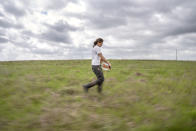 Meredith Ellis winds up a line of electric fence as she opens up a grazing area for her cattle on her ranch in Rosston, Texas, Wednesday, April 19, 2023. For Ellis, regenerative ranching means moving her family’s herd of 320 cows, calves and heifers plus several bulls through 58 fenced pastures. Ellis and her ranch manager further subdivide those pastures using temporary, electrified line they can quickly string to confine cattle in even smaller areas. (AP Photo/David Goldman)