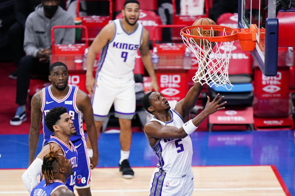 Sacramento Kings' De'Aaron Fox, right, goes up for a shot during the first half of an NBA basketball game against the Philadelphia 76ers, Saturday, March 20, 2021, in Philadelphia. (AP Photo/Matt Slocum)