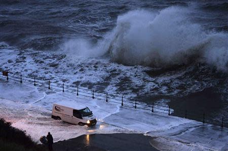 A van drives through seawater washed onto the promenade of the north bay in Scarborough, northern England December 5, 2013. REUTERS/Nigel Roddis