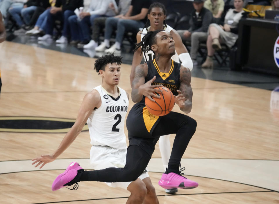 Milwaukee guard Elijah Jamison, front, drives to the basket past Colorado guard KJ Simpson, center, and forward Cody Williams during the first half of an NCAA college basketball game Tuesday, Nov. 14, 2023, in Boulder, Colo. (AP Photo/David Zalubowski)