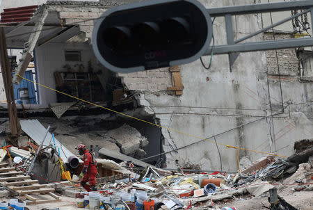 A member of rescue team walks, in the rubble of a collapsed building, after an earthquake in Mexico City, Mexico September 25, 2017. REUTERS/Nacho Doce